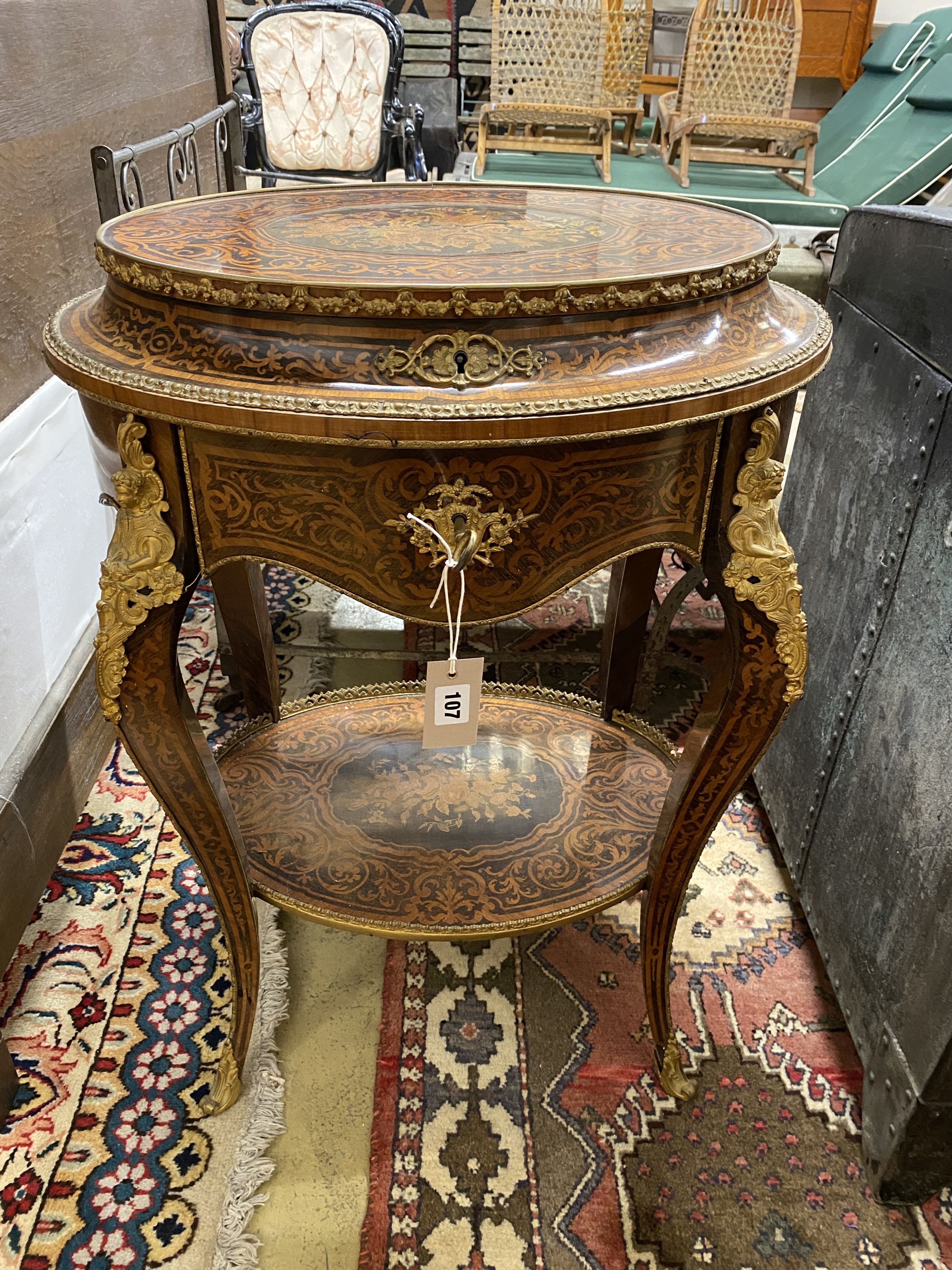 A Louis XVI style marquetry inlaid oval gilt metal mounted two tier work table, width 56cm, depth 42cm, height 78cm